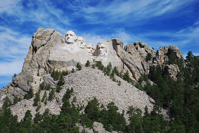 Mount Rushmore with the morning sun shining on the faces of the monument [a granite formation in the Black Hills in Keystone, South Dakota of USA Presidents George Washington, Thomas Jefferson, Theodore Roosevelt, and Abraham Lincoln by artist and sculptor Gutzon Borglum sculpted from 1927 to 1941]. Photo Credit: Bbadgett [CC BY-SA 3.0 (https://creativecommons.org/licenses/by-sa/3.0)], 5 August 2011